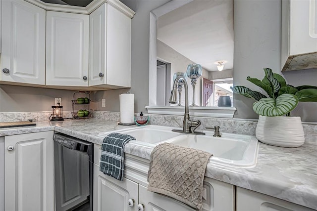 kitchen with stainless steel dishwasher, white cabinets, light stone countertops, and sink