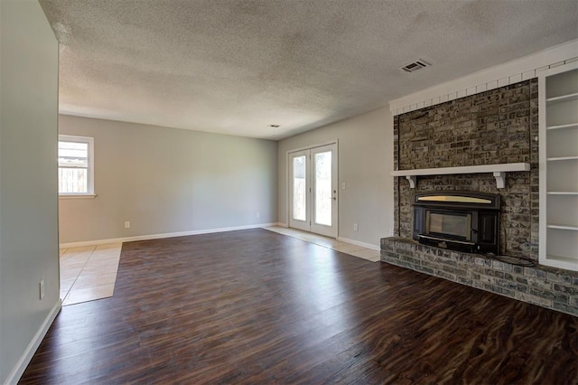 unfurnished living room with a wealth of natural light, wood-type flooring, and a textured ceiling