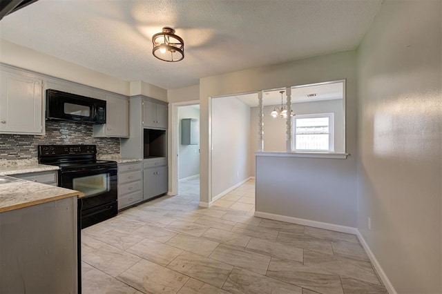 kitchen with gray cabinetry, a notable chandelier, pendant lighting, decorative backsplash, and black appliances