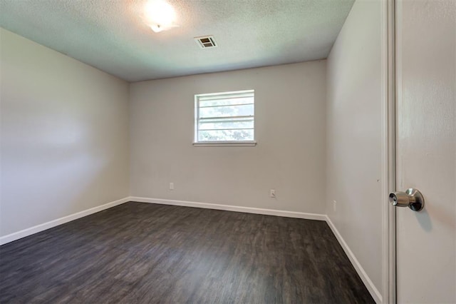 unfurnished room with a textured ceiling and dark hardwood / wood-style flooring