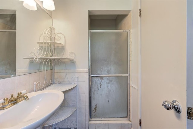 bathroom featuring tile walls, sink, and an enclosed shower