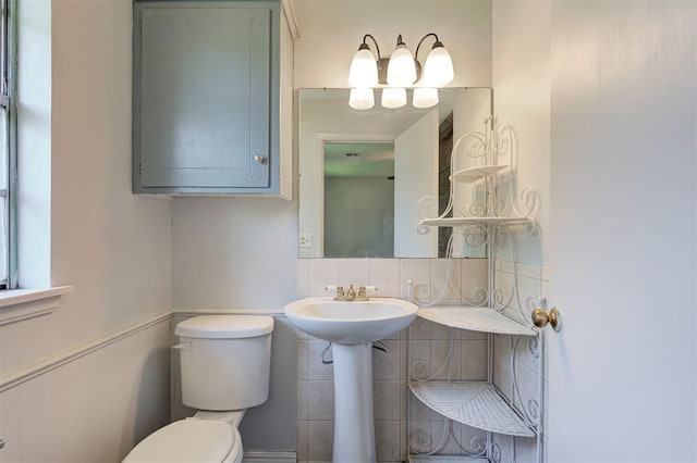 bathroom featuring sink, tile walls, and toilet