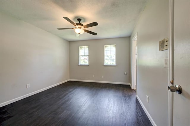 empty room featuring ceiling fan and dark hardwood / wood-style flooring