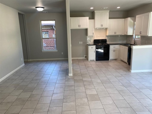 kitchen featuring a wealth of natural light, white cabinetry, and black appliances