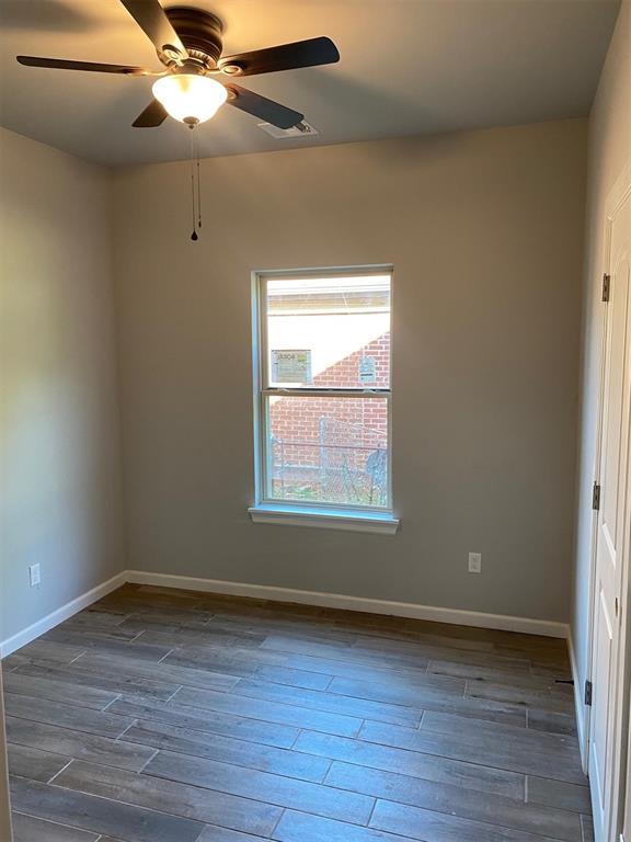 empty room featuring ceiling fan and dark hardwood / wood-style flooring