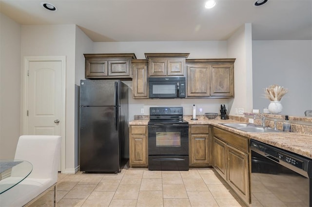 kitchen featuring black appliances, light tile patterned flooring, and sink