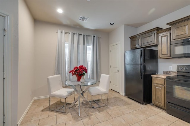 kitchen with black appliances and light tile patterned flooring