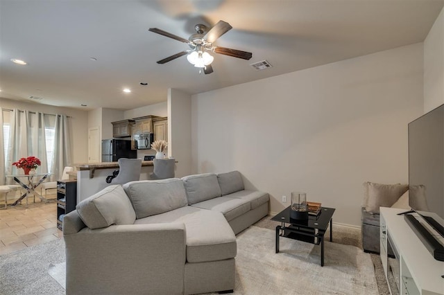 living room featuring light tile patterned floors and ceiling fan