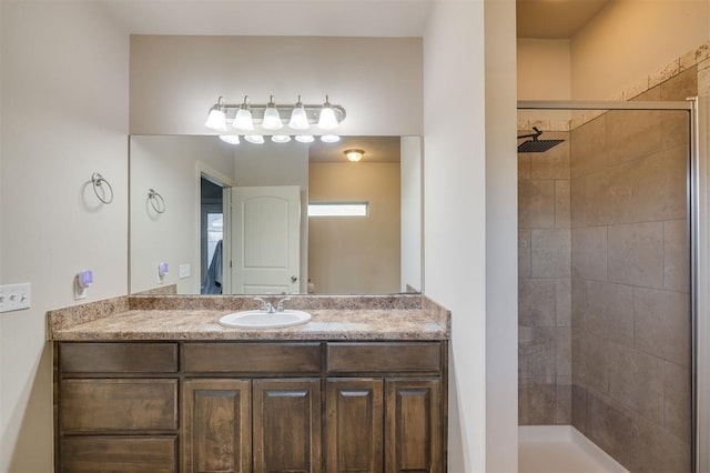 bathroom featuring a tile shower and vanity