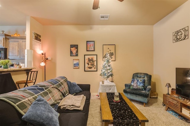 carpeted living room with ceiling fan