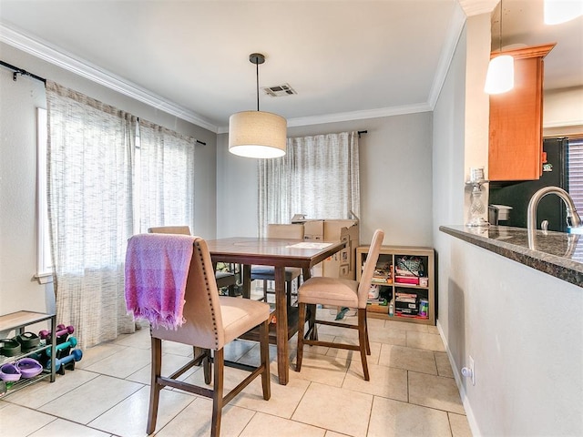 tiled dining space featuring sink and ornamental molding