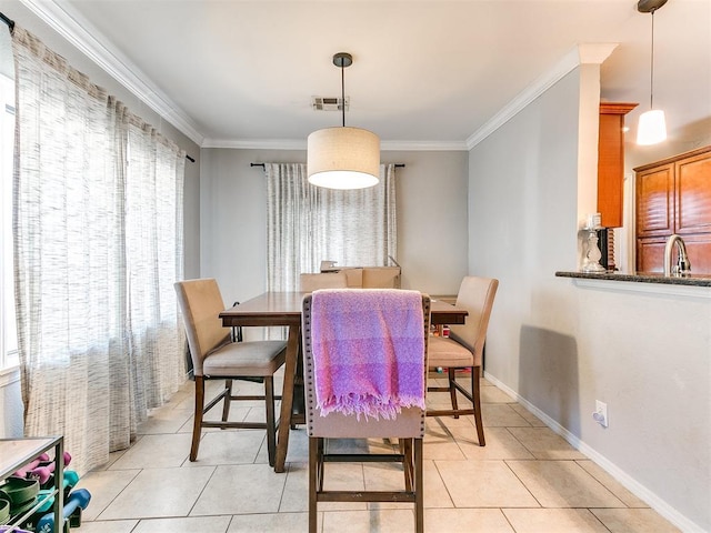 tiled dining area featuring crown molding and sink