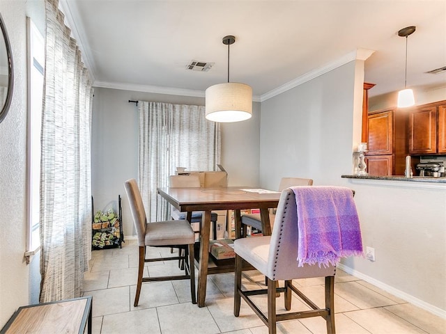 dining space with light tile patterned floors, crown molding, and a wealth of natural light