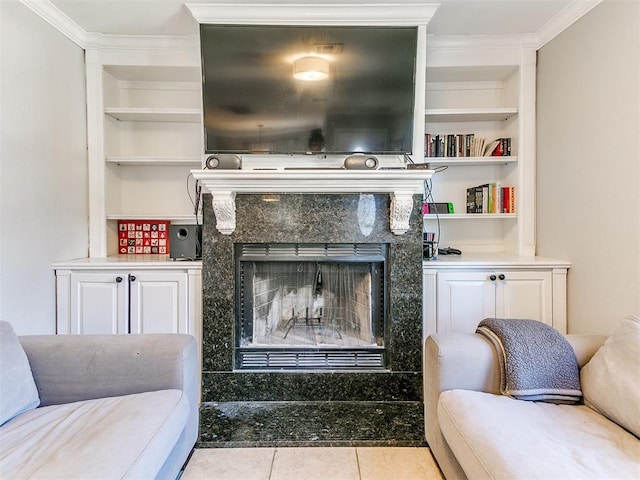 living room featuring light tile patterned flooring, ornamental molding, a fireplace, and built in features