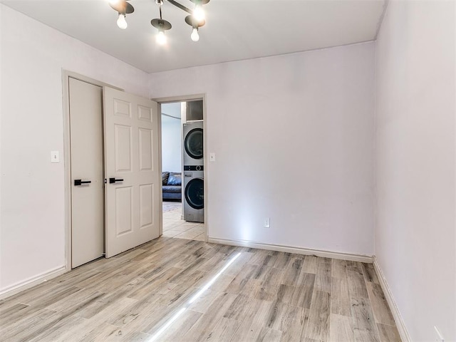 interior space featuring stacked washer / dryer and light hardwood / wood-style floors