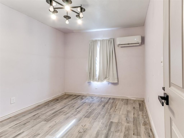 unfurnished room featuring a wall mounted air conditioner and light hardwood / wood-style floors