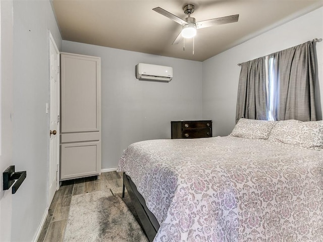 bedroom with wood-type flooring, a wall mounted AC, and ceiling fan