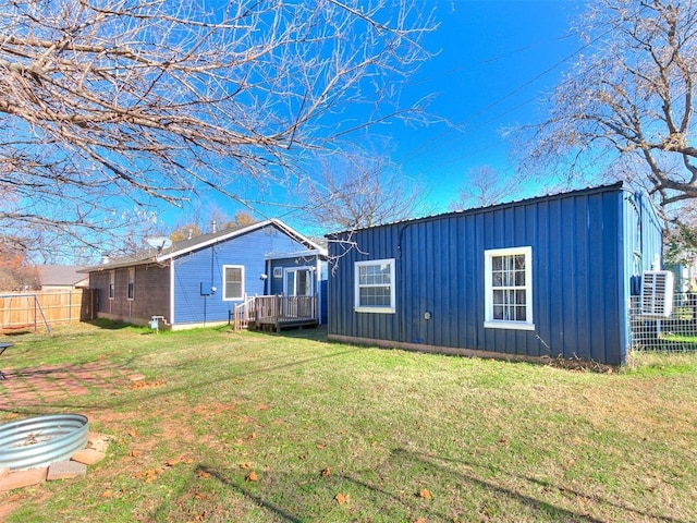 back of house with a lawn and a deck