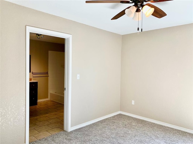 empty room featuring ceiling fan and carpet