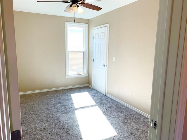 spare room featuring ceiling fan and carpet