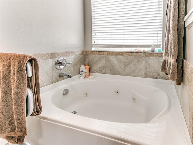 bathroom with a relaxing tiled tub and a wealth of natural light