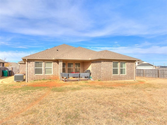 back of house with a yard and central AC