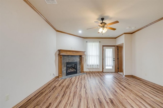 unfurnished living room with a tile fireplace, ceiling fan, light hardwood / wood-style flooring, and ornamental molding