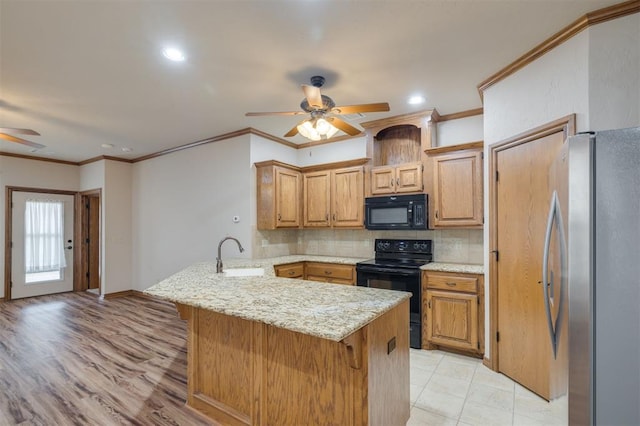 kitchen featuring a breakfast bar, black appliances, crown molding, sink, and kitchen peninsula