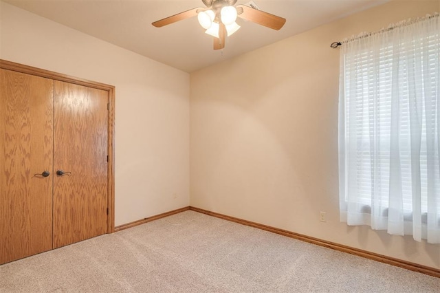 unfurnished bedroom with multiple windows, light carpet, and a closet