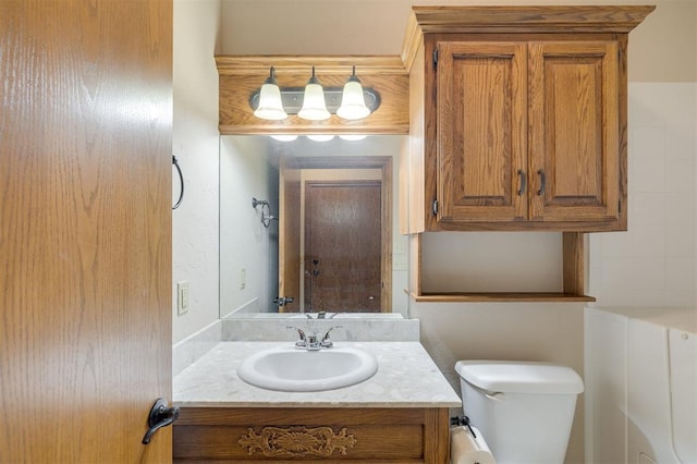 bathroom featuring vanity, toilet, and tasteful backsplash