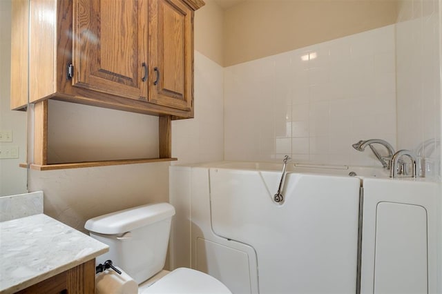 bathroom featuring a bathing tub, vanity, and toilet