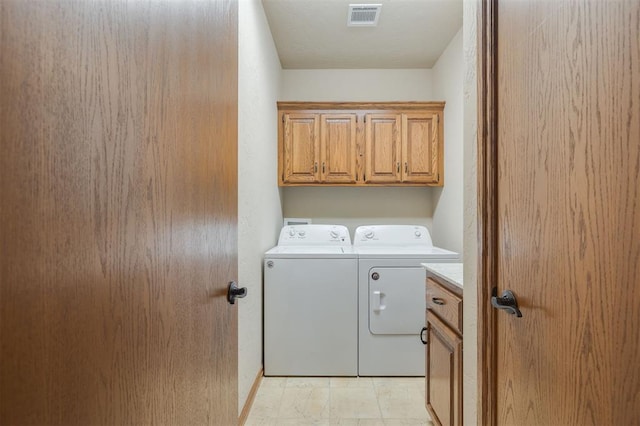 washroom featuring cabinets and washer and dryer