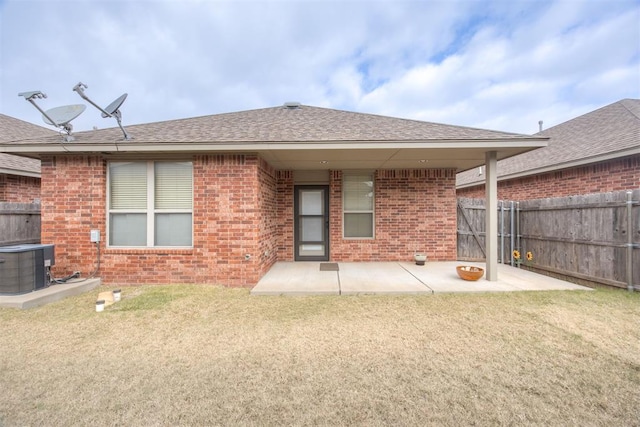 rear view of house with a lawn, central AC unit, and a patio