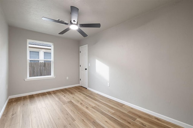 empty room with ceiling fan, a textured ceiling, and light hardwood / wood-style flooring