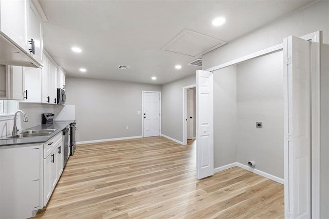 kitchen with light hardwood / wood-style floors, white cabinetry, sink, and stainless steel appliances