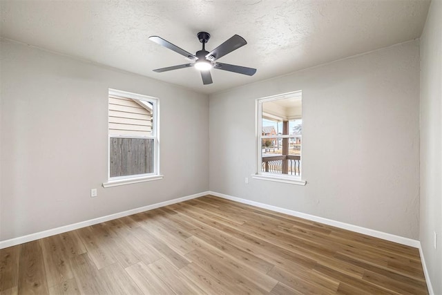 spare room featuring a textured ceiling, light wood-type flooring, and ceiling fan