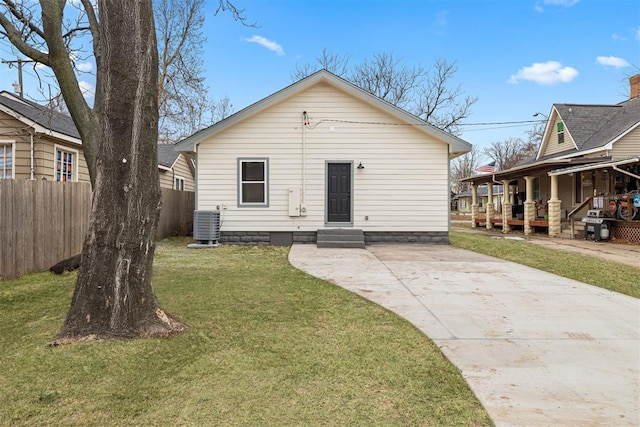 rear view of property with a yard and central AC