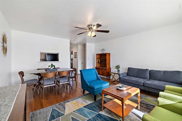 living room featuring ceiling fan and dark hardwood / wood-style floors