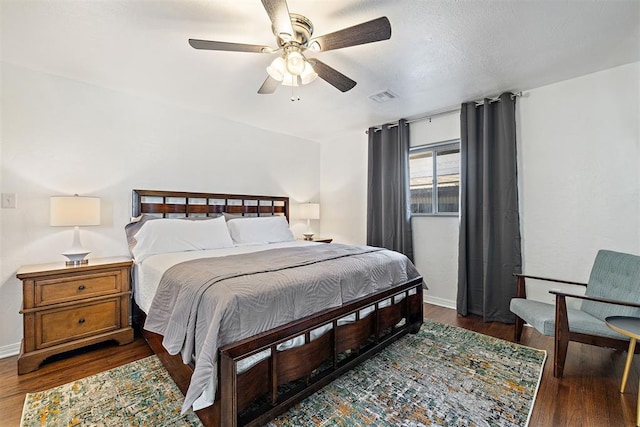 bedroom with dark hardwood / wood-style floors and ceiling fan