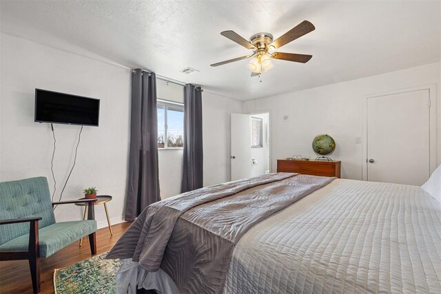 bedroom featuring ceiling fan, a textured ceiling, and hardwood / wood-style flooring