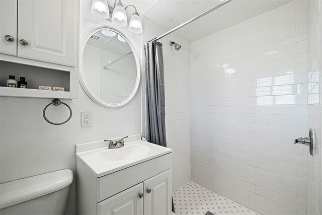 bathroom featuring vanity, curtained shower, and toilet