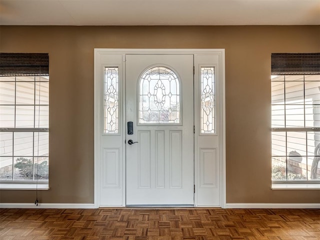 foyer featuring a healthy amount of sunlight and baseboards