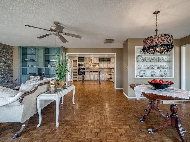 dining area with visible vents, ceiling fan, a textured ceiling, and baseboards