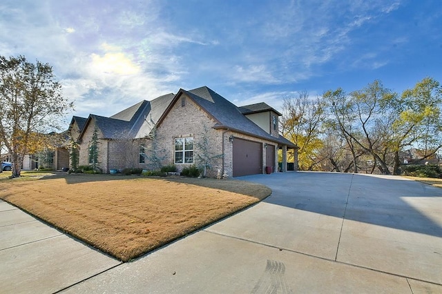 view of front of house with a garage, concrete driveway, and brick siding