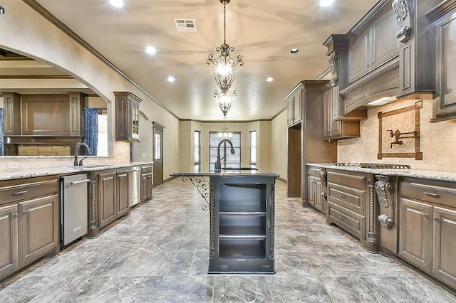 kitchen featuring visible vents, a sink, decorative light fixtures, and dark brown cabinets