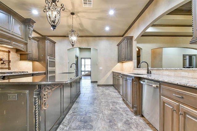 kitchen with visible vents, decorative backsplash, arched walkways, appliances with stainless steel finishes, and a sink