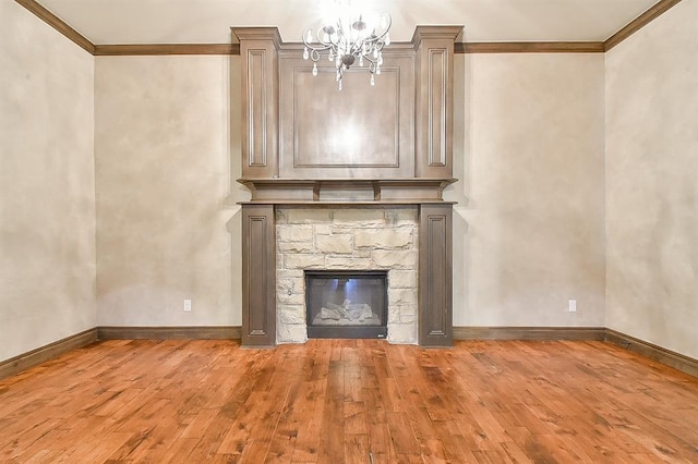 unfurnished living room featuring light wood-style flooring, ornamental molding, baseboards, and a stone fireplace