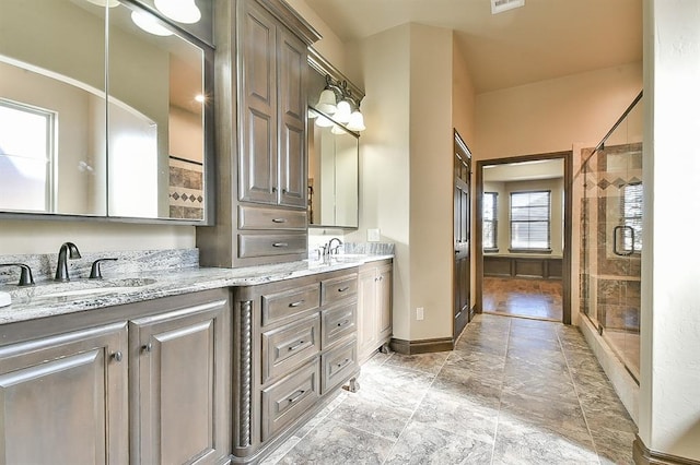 bathroom featuring double vanity, a sink, visible vents, and a shower stall