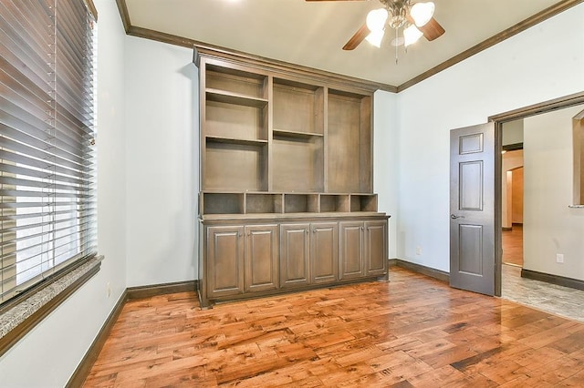 interior space with a ceiling fan, crown molding, baseboards, and wood finished floors