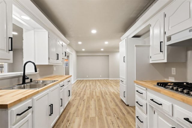 kitchen with white cabinetry, light wood-type flooring, and wood counters